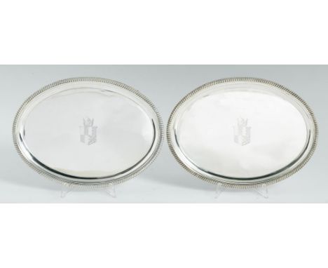 A PAIR OF GEORGE III OVAL SILVER WAITERS moulded cavetto and gadrooned rim, on four conforming feet,  engraved with armorials