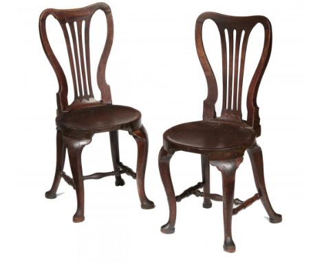 A PAIR OF GEORGE II MAHOGANY HALL CHAIRS, C1750  with spoon back and dished, almost round seat, on cabriole legs united by st