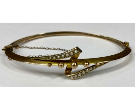 9CT GOLD HOLLOW BANGLE set with split seed pearls, hinged with safety chain, 45 x 16mms, 5.3gmsProvenance: private collection