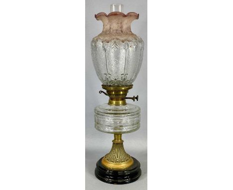 VICTORIAN OIL LAMP with black ceramic base, embossed brass column, faceted clear glass reservoir, twin burners and moulded cl