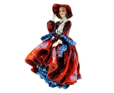 Vintage figure of a woman with hat and dress blowing in the wind. Blue and vermillion coloration. Royal Doulton backstamp. A 