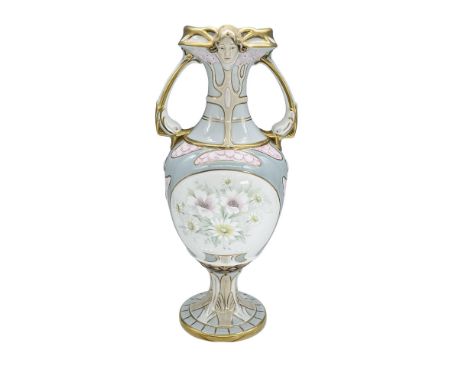 Tall elegant vase with handles in light blue and white coloration with delicate pink and yellow flowers. The face of a lady d