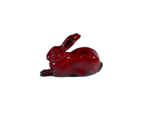 This exquisite animal figurine features a hare poised gracefully in a crouched position, beautifully rendered in a rich red g