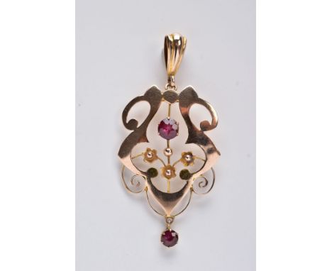 A YELLOW METAL OPENWORK PENDANT, of an openwork scroll and floral design, set with a central circular cut garnet also suspend