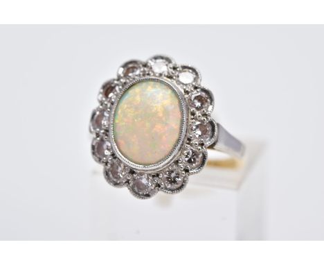 A WHITE METAL OPAL AND DIAMOND CLUSTER RING, designed with an oval opal cabochon, within a milgrain setting and round brillia