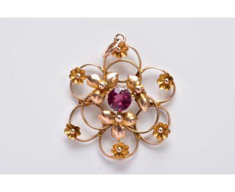 A YELLOW METAL OPENWORK PENDANT, in the form of an openwork flower set with a central circular cut garnet, with decorative fo