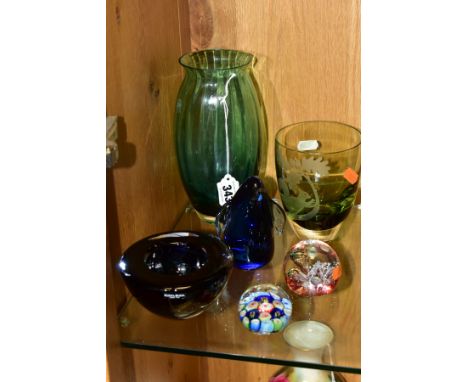 SIX PIECES OF MODERN COLOURED GLASSWARE, including three paperweights, one of penguin form, a Kosta Boda amethyst swirl heavy