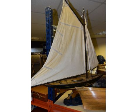 A WOODEN POND YACHT, missing rudder, sails and rigging in need of some minor attention, playworn with paint loss and wear, si