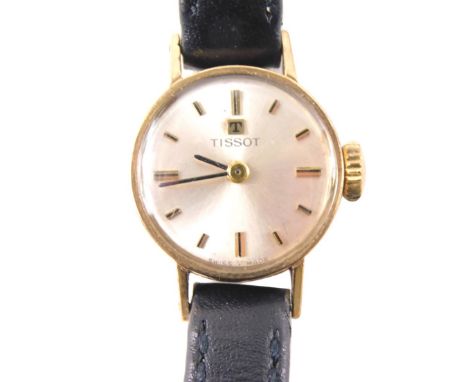 A Tissot 9ct gold ladies wristwatch, with small circular watch head on a silvered dial, 1.5cm wide, with a thin black leather