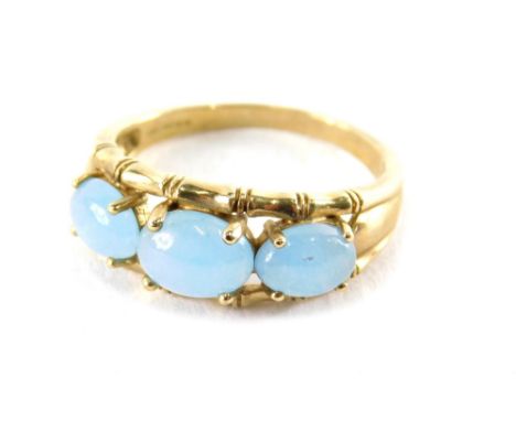 A 9ct gold three stone dress ring, with three polished cabochon pale blue stones, bamboo outer work setting, ring size R, 3.6