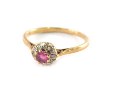 A 9ct gold garnet and diamond cluster ring, the round brilliant cut raised garnet in a eight claw settings, surrounded by ill