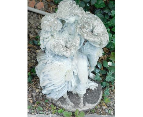 A composition stone statue, model in the form of male and female lovers on a circular base, 70cm high.