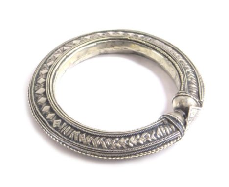 A highly elaborate Middle Eastern bangle, set with arrow heads and diamonds, with diamond shape clasp, unmarked, 11cm wide. 