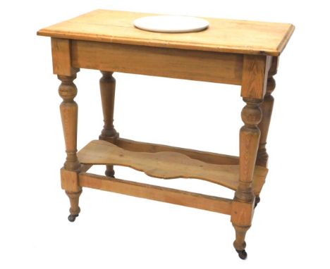 A 19thC pine washstand, the top inset with an associated ceramic wash bowl, printed George VI 1951, on turned supports with u