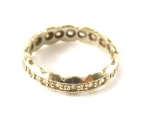 A 9ct gold eternity ring, set with cz stones, with wave design outer border, ring size K½, 2.3g all in.