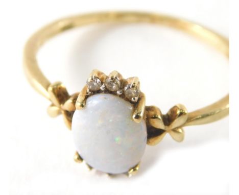 A 9ct gold opal and diamond dress ring, the oval opal in four claw setting with six tiny diamonds, and X set shoulders, ring 