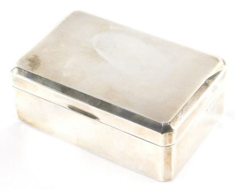 A George VI silver cigarette box, with engine turned canted top, thumb mould handle and cedar lined interior, Birmingham 1937