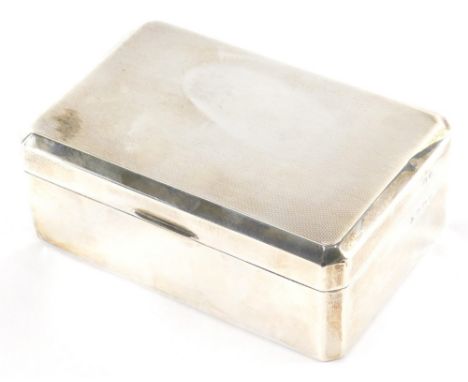 A George VI silver cigarette box, with engine turned canted top, thumb mould handle and cedar lined interior, Birmingham 1937