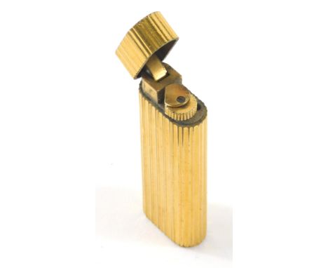 A cartier pocket lighter, the oblong body with raised line decoration,  8cm high. 