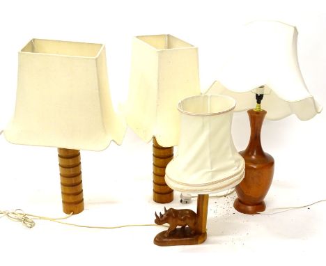 A pair of Eastern hardwood turned wooden table lamps, a similar table lamp decorated with a rhino and a plain baluster shaped