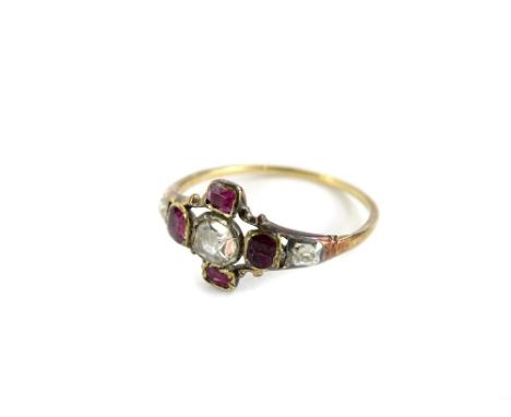 A Victorian dress ring, set in star design, with old cut central diamond, surrounded by four garnets, in thin yellow metal se