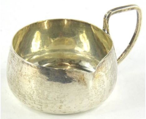 An Edwardian Arts &amp; Crafts silver side handled milk jug, of plain form, with angular handle, Chester 1904, by Edward John