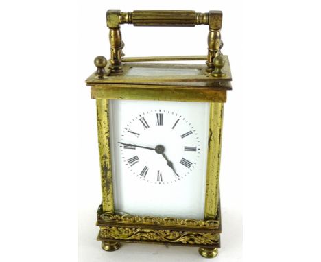 A late 19thC French brass carriage timepiece, the white enamel dial with Roman numerals, the case decorated with pierced foli