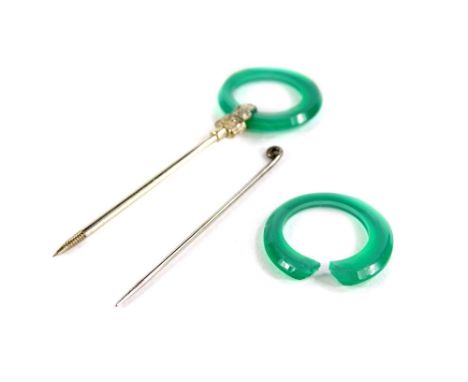 A 14ct white gold jade set pin, the 14ct gold pin with etched design loop holding a circular jade ring, a further jade ring (