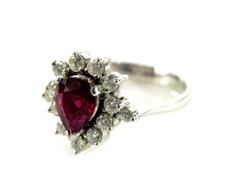 An 18ct white gold floral cluster ring, set with tier drop design, central ruby, surrounded by round brilliant cut tiny diamo