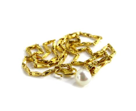 A cultured pearl pendant necklace, the single cultured peal pendant with an 18ct gold setting, on a fancy link eastern style 