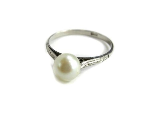 A cultured pearl dress ring, with single cultured pearl, in tension setting, with scroll design shoulders, white metal, beari