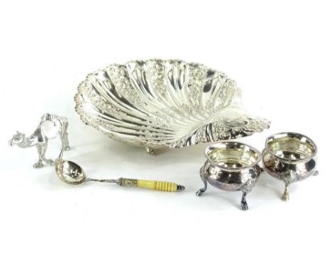 An early 20thC silver plated dish, of shell shaped form, bright cut and repousse decorated with scrolls, initial to the handl