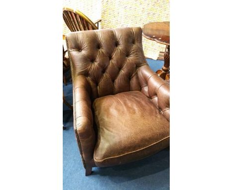 A good quality brown leather button back armchair and matching foot stool