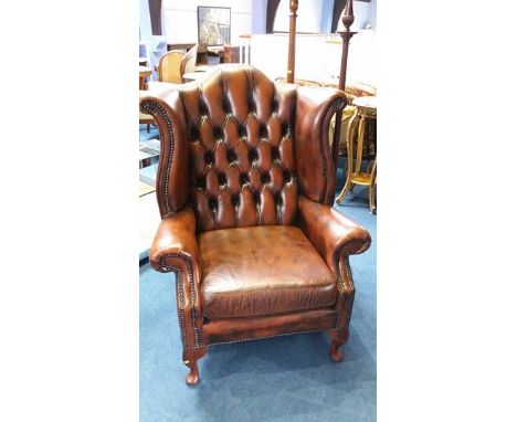 A Chesterfield brown leather button back armchair