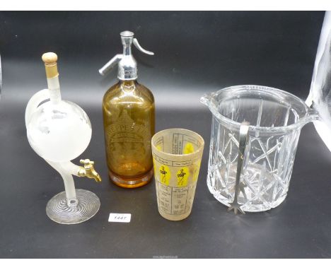 A large glass ice bucket with metal tongs, a glass drinks measure, a Schwepps limited porcelain lined siphon and a Highland m