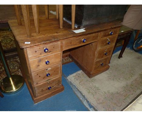 A Victorian Pine Kneehole Desk with cobalt blue ceramic and brass knobs, some locks and key, 48'' wide x 25 1/2'' deep x 29 1