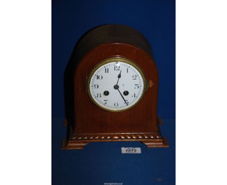 A dome topped Mahogany cased mantle clock having a French two-train movement striking on a coiled gong, the convex enamel fac