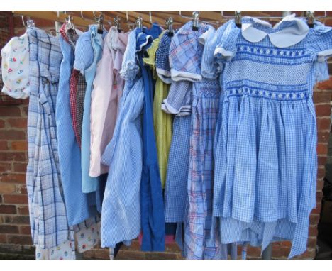 A COLLECTION OF VINTAGE CHILDRENS DRESSES, varying fabrics, patterns and sizes, together with a vintage M&amp;S duffel coat (