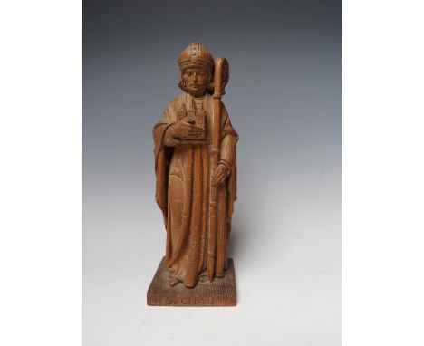 A MID 20TH CENTURY CARVED WOODEN FIGURE OF ST CHAD OF LICHFIELD, initialled H.C and dated 1952 to base below a carved 'bee' m