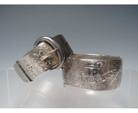 A HALLMARKED SILVER HINGED BANGLE WITH ENGRAVED DESIGN - CHESTER 1958, together with a hallmarked silver 'buckle' bangle, app