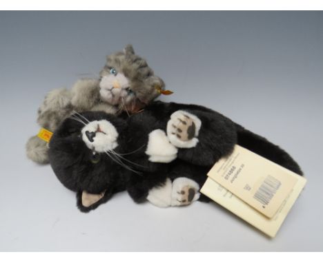 A STEIFF PLUSH BLACK &amp; WHITE CAT, yellow tag in ear No 074868, original tag 'Jungkatze 20', W 26 cm, together with a grey