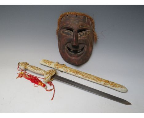 A CHINESE YAO MINORITY TRIBAL WOODEN FACE MASK, H 21 cm, together with a modern Chinese sword, L 50 cm (2)