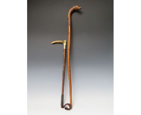 A VINTAGE WALKING STICK WITH CARVED HANDLE TERMINATING IN DOGS HEAD, L 79 cm, together with a riding crop (2)