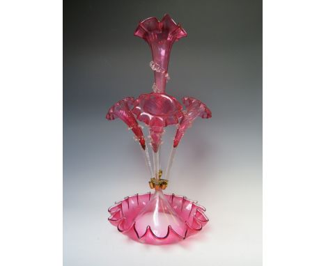 A VICTORIAN CRANBERRY GLASS EPERGNE, with central cranberry flower holder, three further  flower holders, all on a shaped cra