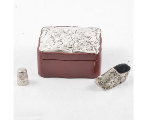 A red leather trinket box with silver mount to lid, Keyford Frames Ltd, London 1983, cherub design to mount, 8.5cm x 9.5cm; a