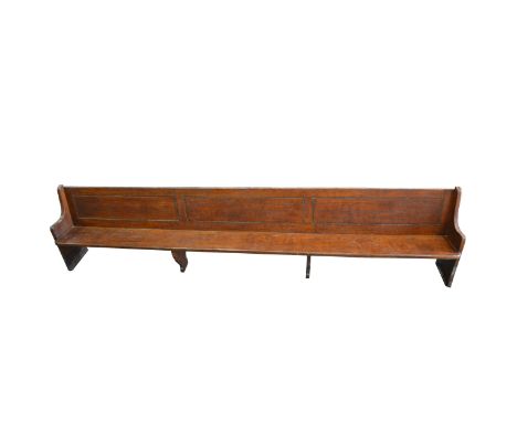 Oak bench, three rectangular panels to the back, boarded seat, standard ends, length 427cm, depth 45cm, height 93cm. Removed 