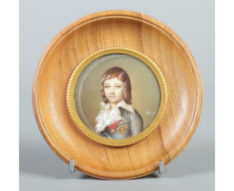 A circular framed portrait miniature depicting a child. 5.5cm diameter.  