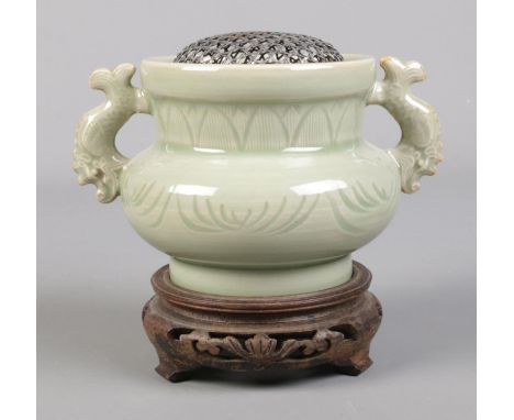 A Chinese celadon censor, with silver meshed inset, raised on carved hardwood stand. Total height 12cm.  