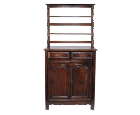 A French oak bookcase cabinet, 18th century and later, the moulded cornice with two shelves above the base with rectangular t