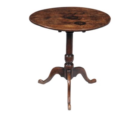 An oak tripod table, early 18th century, the oval tilt top above turned stem and tripod base, 71cm high, the top 65cm x 69cm 